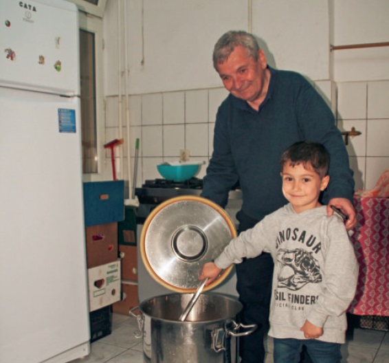 Der kleine Georg geht Caritas Direktor Herbert Grün zur Hand bei der Zubereitung der Suppe für das Obdachlosenheim