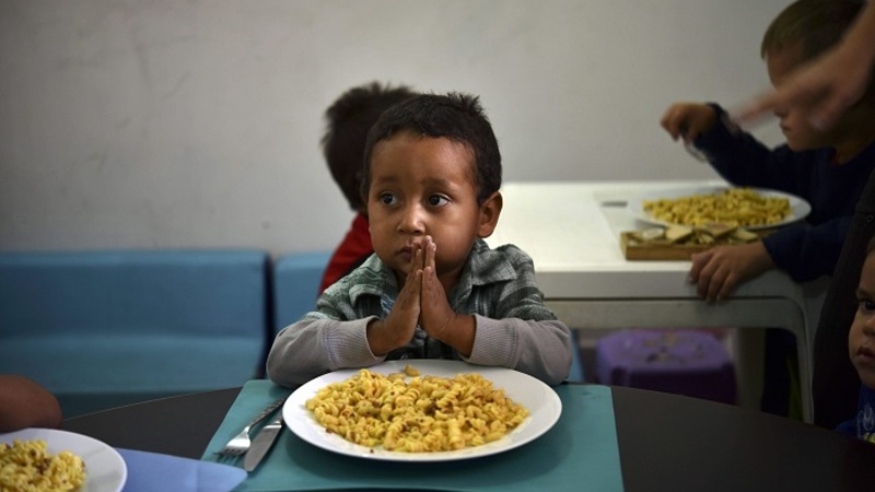Download von www.picturedesk.com am 22.02.2019 (11:20). TOPSHOT - A child prays before eating at the Kapuy Foundation shelter -which supports children in situation of abandonment or with serious health problems, including undernourishment- in Maraca