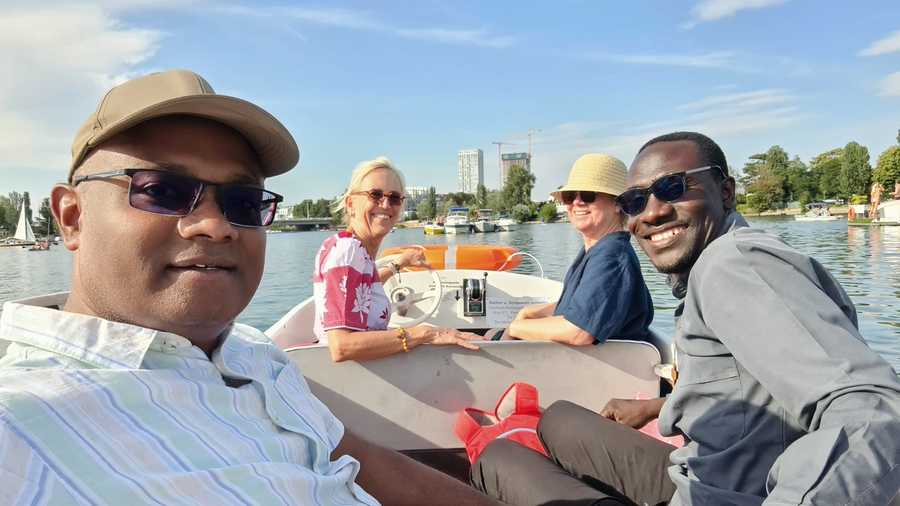 Ulrike Hifinger Vier Personen, darunter ein Mann mit Sonnenbrille, sitzen in einem Boot auf dem Wasser. Sie alle lächeln und genießen ihre Zeit miteinander