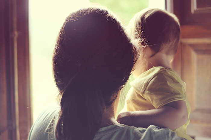 Family concept. Mother holding her little daughter next to the w