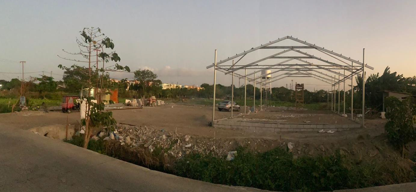 Der Bauplatz der Pfarre. Links die kleine Brücke als Zufahrt. Das aufgeschüttete Terrain (links fehlen noch Teile) und das  Metallgerüst der provisorischen Kapelle (vor etwa drei Wochen), die später eine Art Pfarrsaal werden soll. Vermutlich  sind in